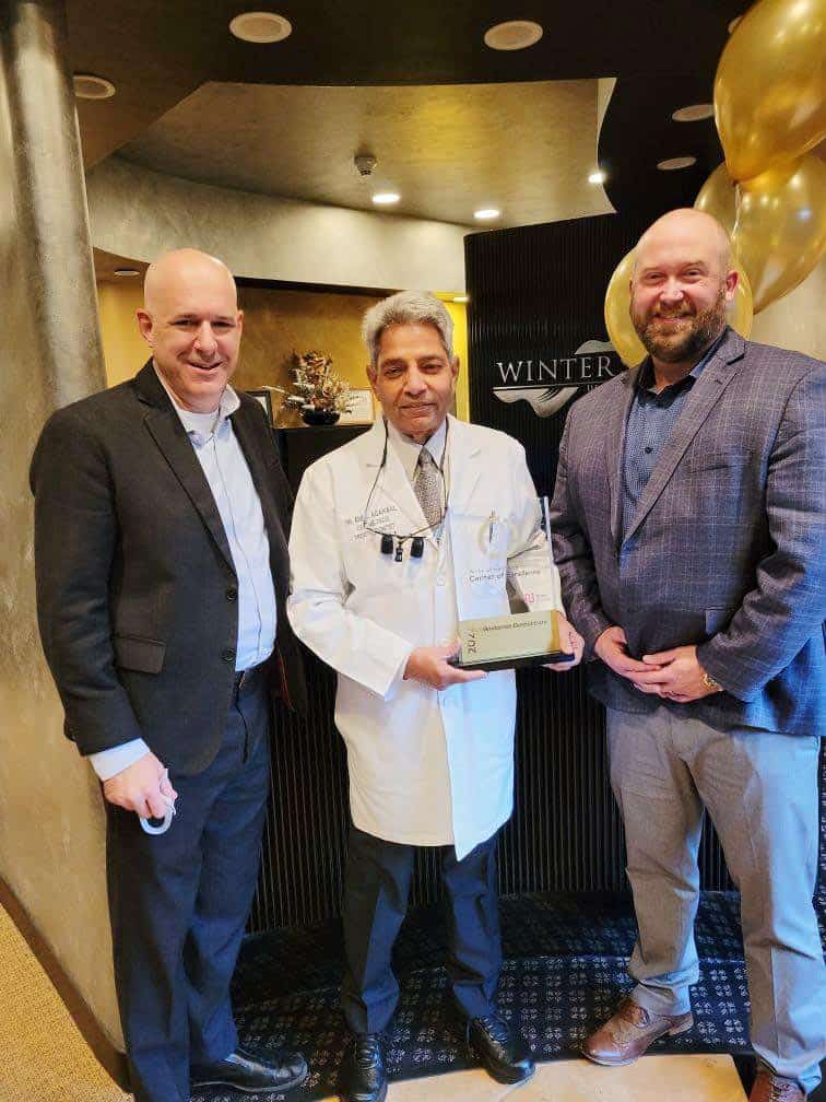 Image of Dr. Anil Agarwal receiving "The Center of Excellence Award" by Nobel Biocare. Pictured with Dr. Agarwal are the Regional Manager and Mid-west Manager of the company.