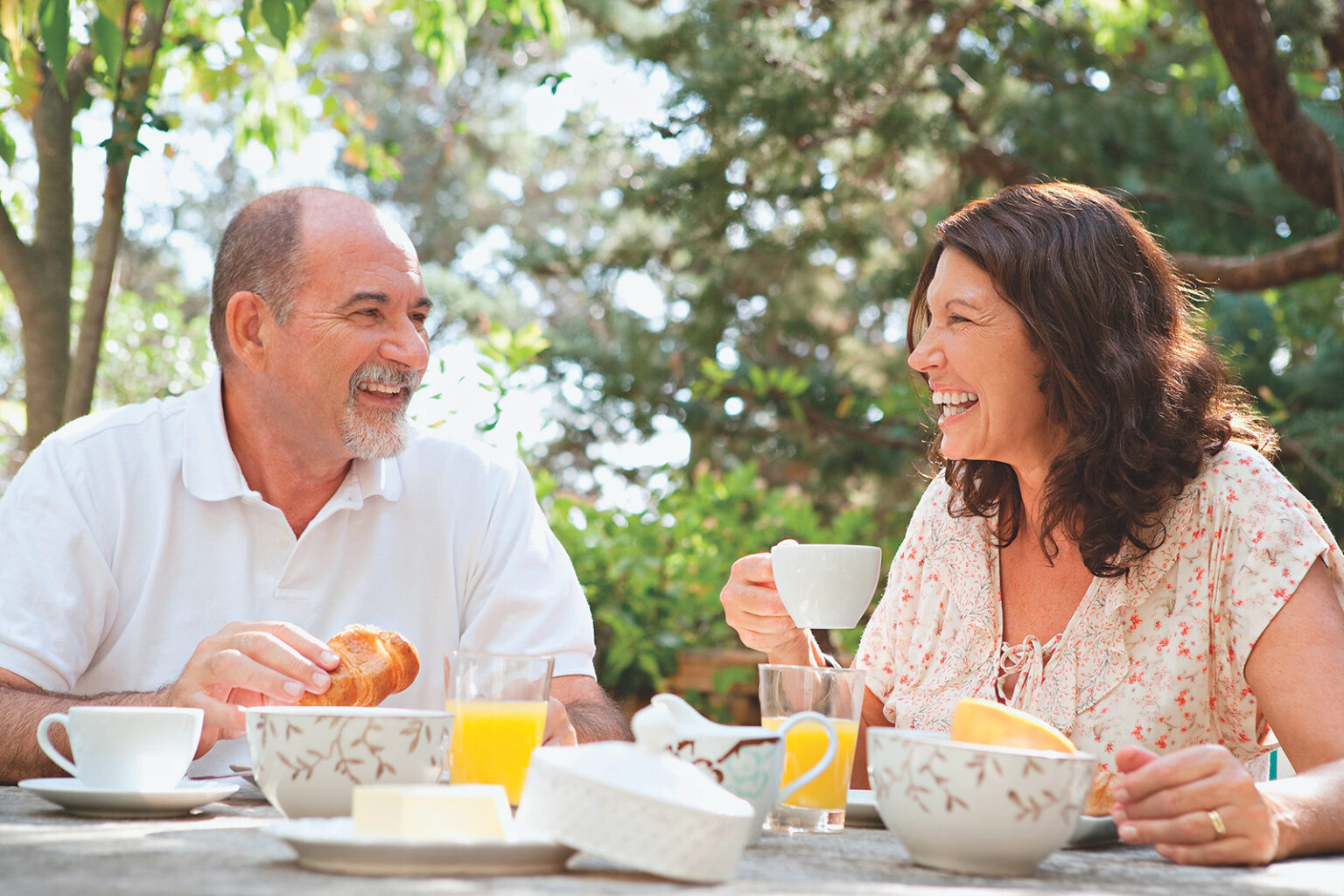 Older couple eating together at a table outside