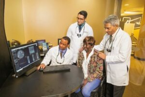 Doctors show a patient some digital x-rays on a computer screen