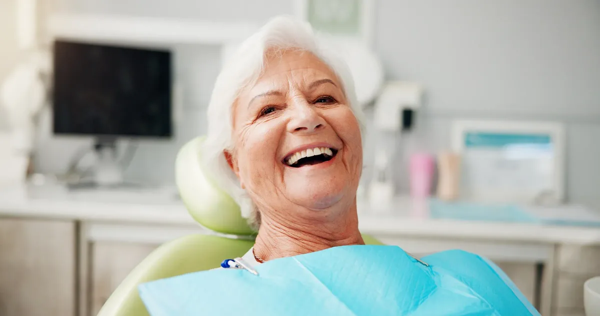 Older woman smiling comfortably in a dental chair